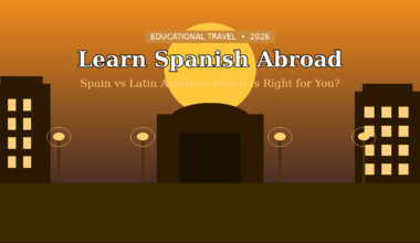 Featured hero graphic for Lexica Routes titled Learn Spanish Abroad: Spain vs Latin America: Which Is Right for You?, displaying a tag at the top for EDUCATIONAL TRAVEL • 2026. The visual layout presents a minimalist flat vector cityscape at sunset, featuring dark brown silhouettes of a large central arched building gateway, two flanking apartment buildings with lit windows, and stylized streetlights arranged before a massive glowing yellow sun against a deep orange-to-brown gradient sky.